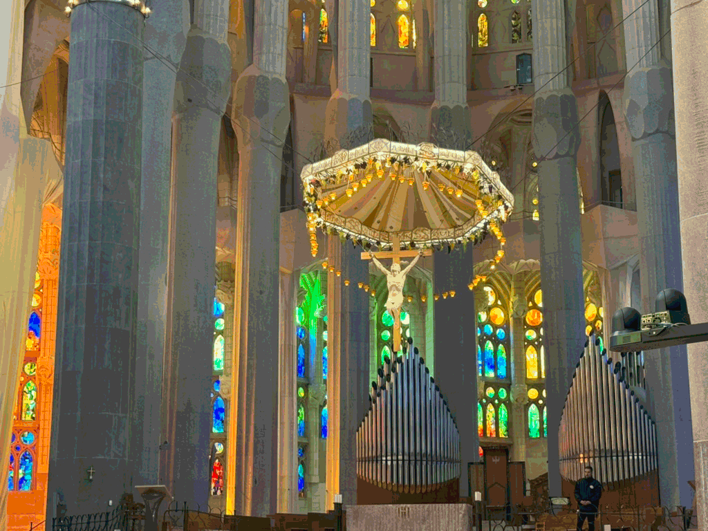 Interior of Barcelona’s Sagrada Família with its suspended crucifix and stained glass