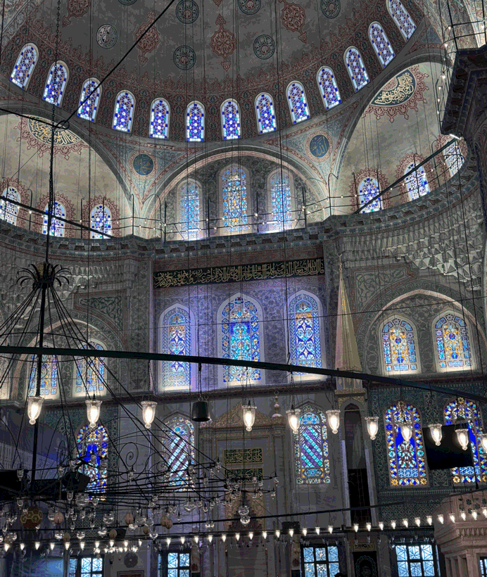 Blue stained-glass windows and decorated dome inside Sultan Ahmed Mosque